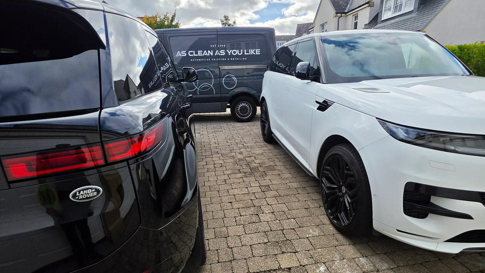 Two Land Rover Range Rovers freshly valeted on a residential driveway in Cramond, with the AS-CLEAN branded van behind them