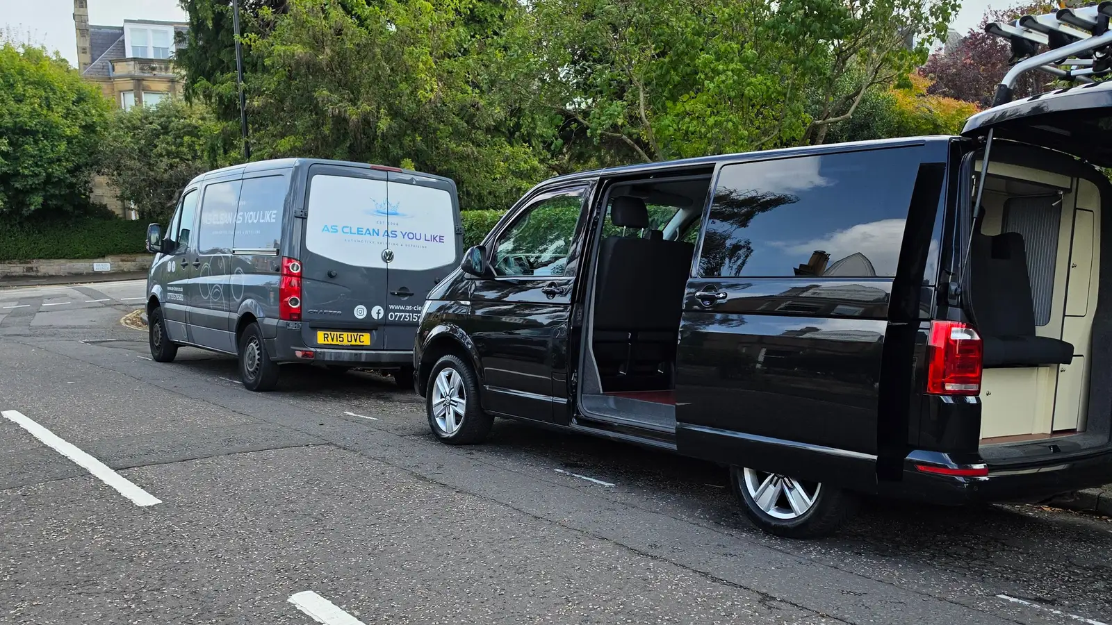A black camper van with doors open during a mobile valet on a leafy residential street in Morningside, Edinburgh