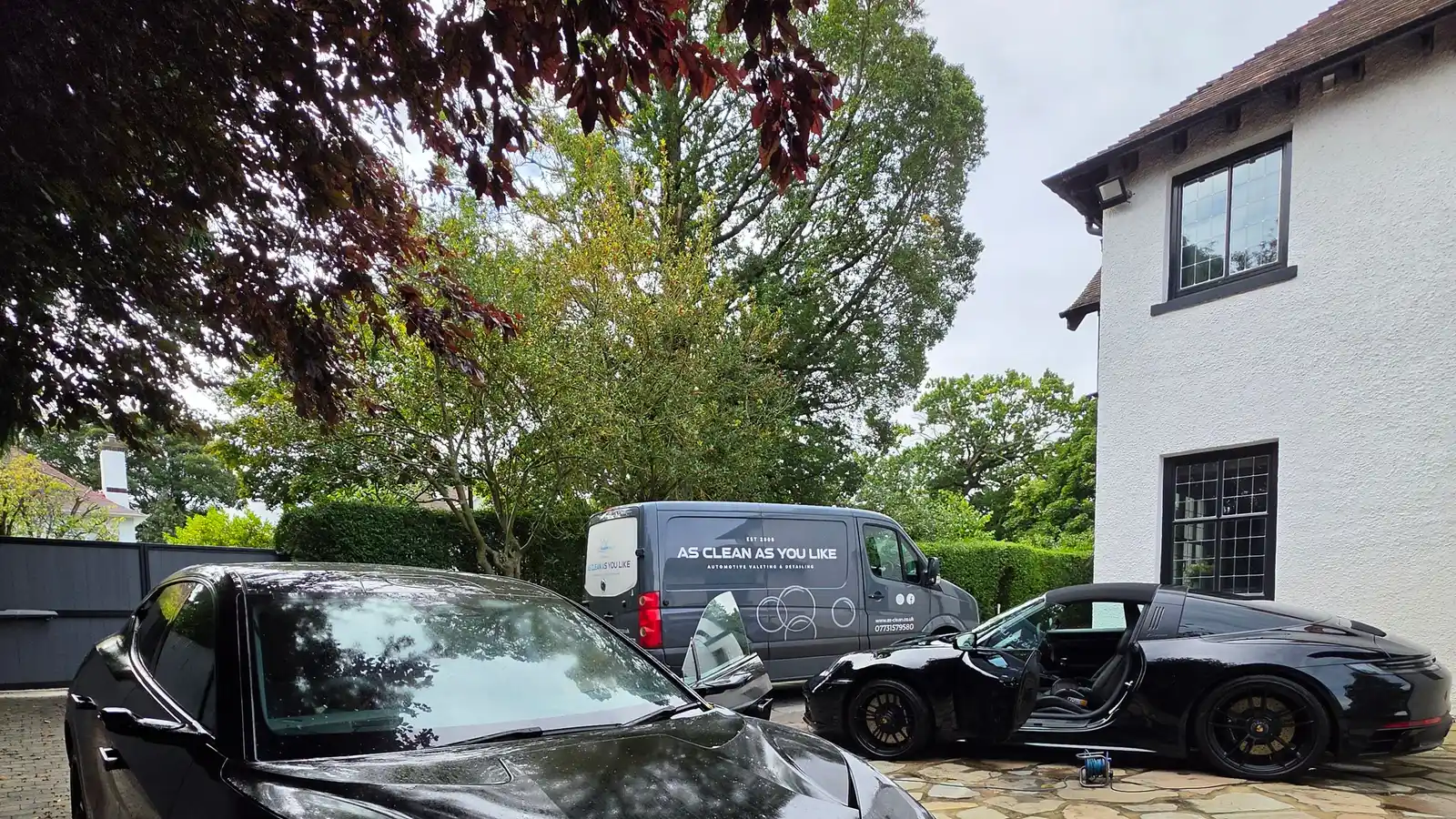 A Lotus and a sports car freshly detailed on a private driveway outside a grand residence in Ravelston, Edinburgh